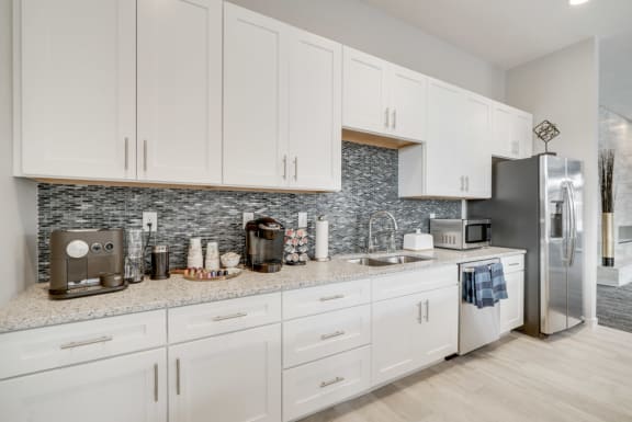 A kitchen with white cabinets and a granite countertop.