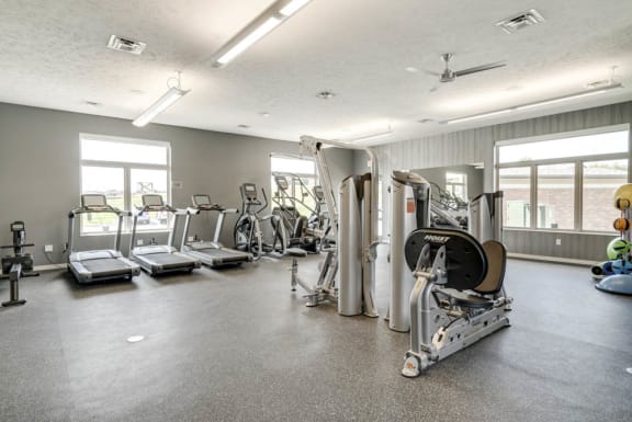 A spacious gym with treadmills, exercise bikes, and other equipment.