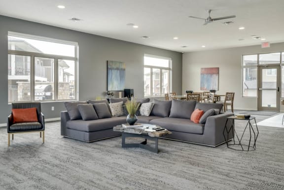 A grey sectional sofa with a coffee table in front of it.