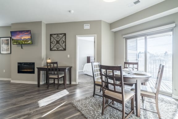 A dining room with a fireplace and a television mounted on the wall.