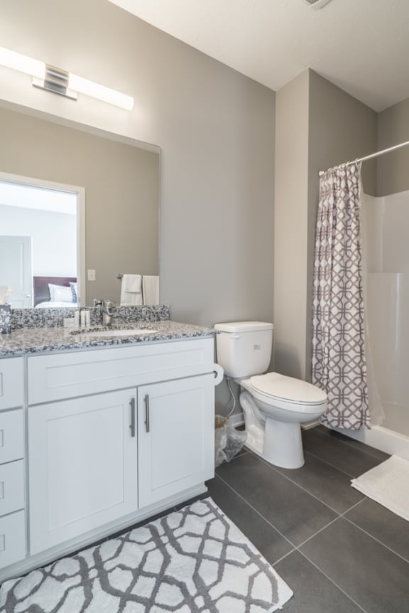 A bathroom with a toilet, sink, and shower.