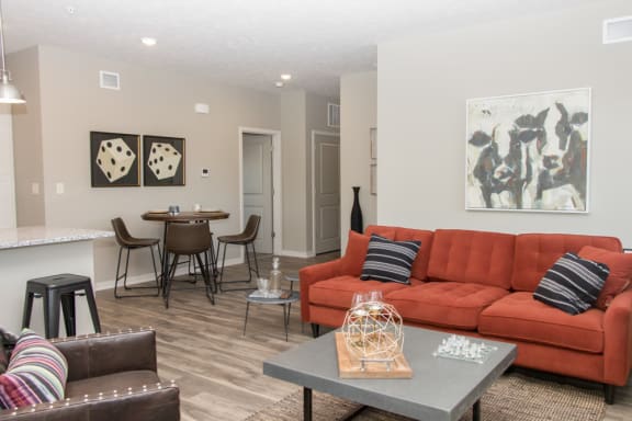 A living room with a red couch and a grey coffee table.