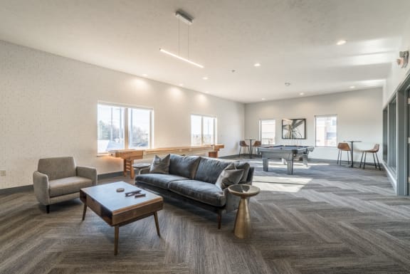Comfortable seating in the clubhouse Dining and living area with dark hard wood finishes at The Villas at Mahoney Park in North Lincoln, Nebraska