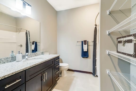Master bathroom with shelving for storage at 360 at Jordan West in West Des Moines, IA