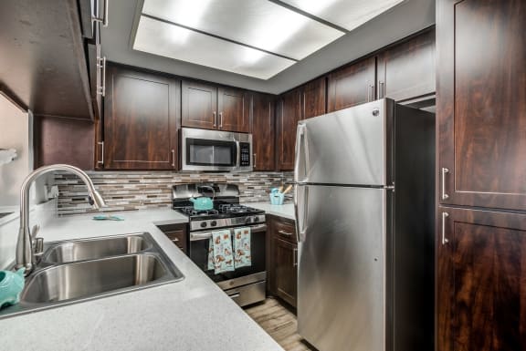 Renovated Kitchen with espresso cabinets, white countertops and stainless steel appliances