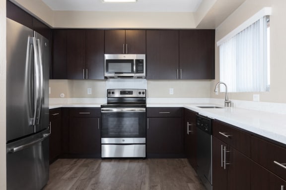 a kitchen with dark cabinets and stainless steel appliances