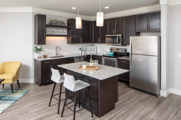 a kitchen with a large island and stainless steel appliances at The Edison at Avonlea, Minnesota,55044