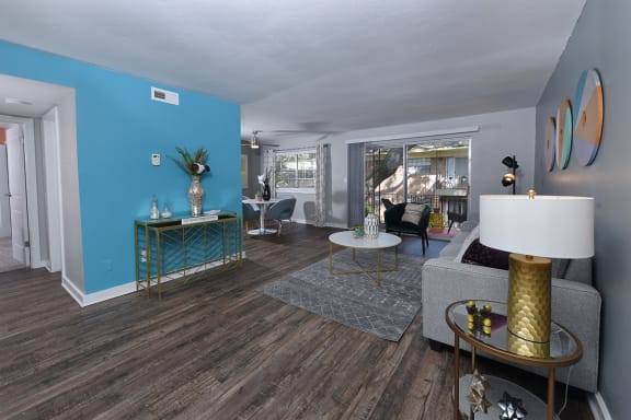 Living area in Watermarc apartment with blue accent wall and wood-style plank flooring