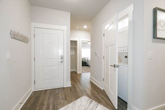 A hallway with white doors and a framed picture on the wall at McHenry Square Apartments, Augusta, GA