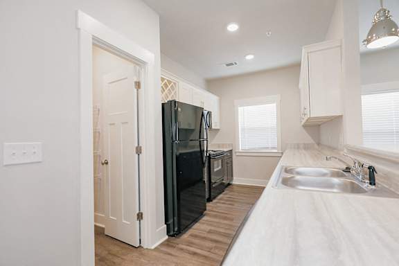 A kitchen with a black refrigerator and a sink with a faucet at McHenry Square Apartments, Augusta, GA, 30909