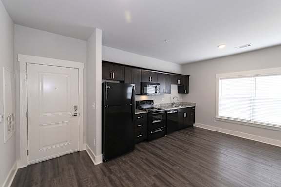 A kitchen with black appliances and wooden floors. at McHenry Square Apartments, Augusta, GA, 30909