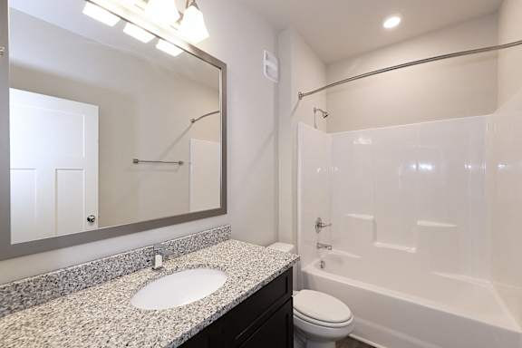 A bathroom with a sink, toilet, and bathtub at McHenry Square Apartments, Augusta, GA