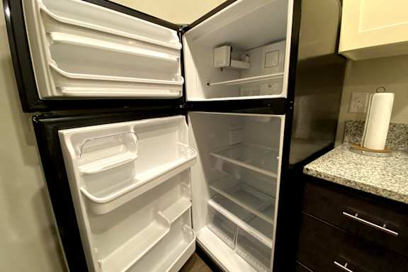A white refrigerator with its door open and empty at McHenry Square Apartments, Augusta, Georgia