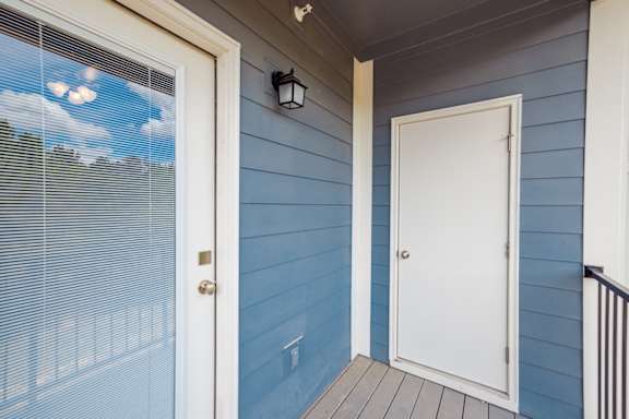 A white door is on the right side of a blue wall at McHenry Square Apartments, Augusta, Georgia