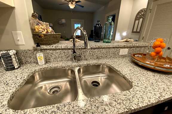 A kitchen with granite countertops and a double sink at McHenry Square Apartments, Augusta