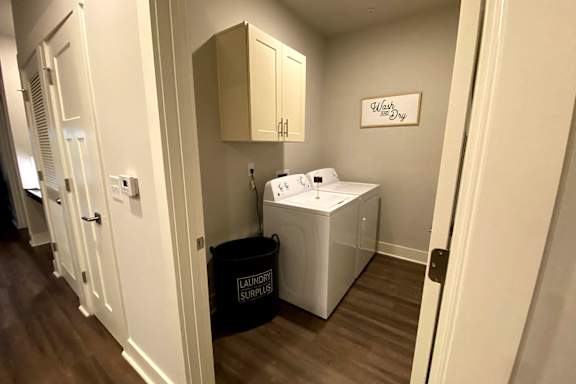 A small laundry room with a washer and dryer at McHenry Square Apartments, Georgia