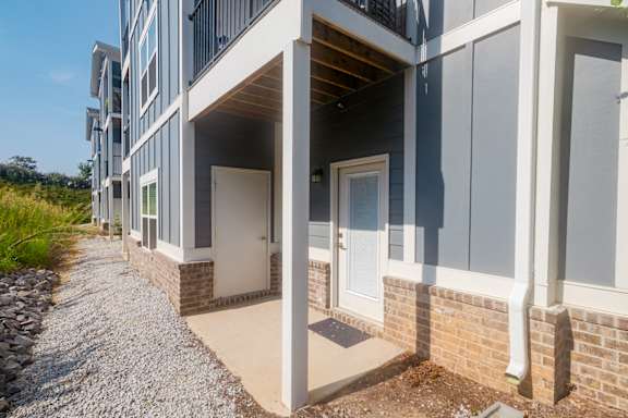 A modern building with a gravel pathway leading to the entrance at McHenry Square Apartments, Georgia, 30909