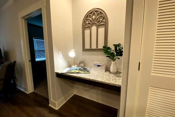 A white bathroom with a mirror and a plant on the counter at McHenry Square Apartments, Georgia, 30909