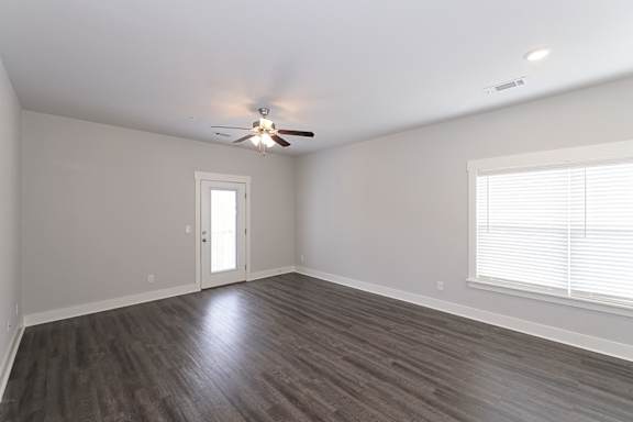 A room with a ceiling fan and a window with blinds at McHenry Square Apartments, Augusta