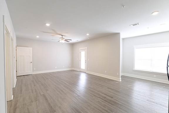 A spacious room with a ceiling fan and lighting fixtures at McHenry Square Apartments, Georgia