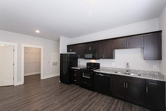 A kitchen with black cabinets and appliances at McHenry Square Apartments, Augusta, Georgia