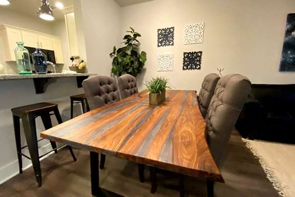 A wooden table with grey chairs and a potted plant on it at McHenry Square Apartments, Augusta, GA