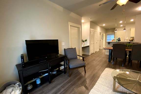 A black television sits on a wooden stand in a living room at McHenry Square Apartments, Georgia