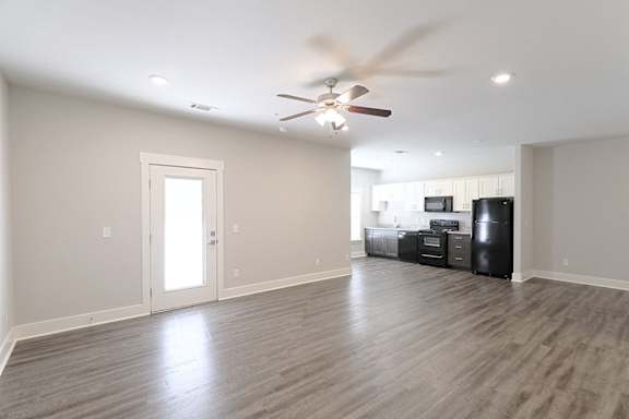 A room with a ceiling fan and a black refrigerator at McHenry Square Apartments, Georgia, 30909