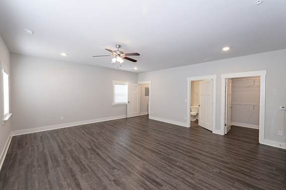 A spacious room with a ceiling fan and lighting fixtures at McHenry Square Apartments, Augusta