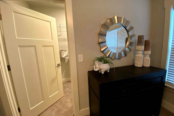A black dresser with a mirror and a small white unicorn figurine on top at McHenry Square Apartments, Georgia, 30909