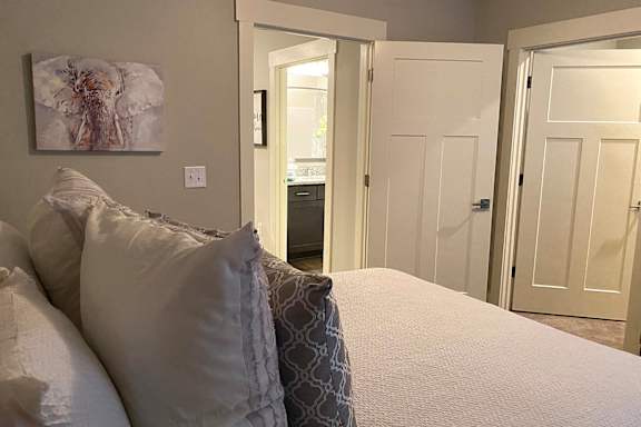 A bedroom with a bed, pillows, and a painting on the wall at McHenry Square Apartments, Augusta, GA, 30909