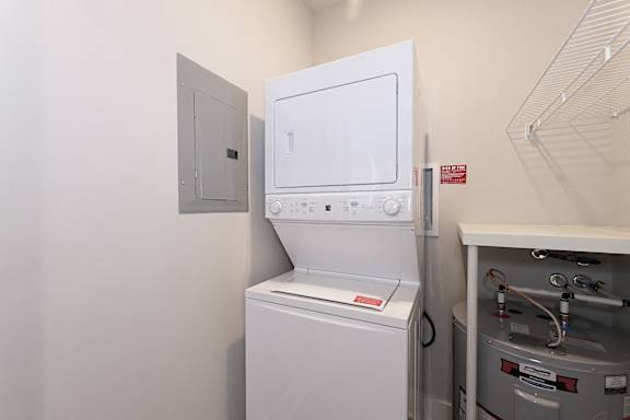 A white microwave oven is on a shelf in a kitchen at McHenry Square Apartments, Georgia, 30909