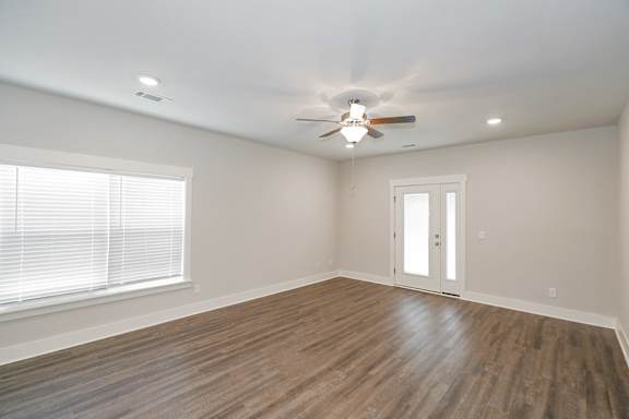 A room with a ceiling fan and a door at McHenry Square Apartments, Georgia