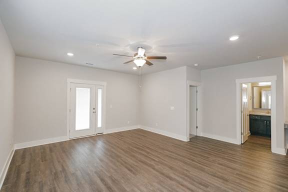 A room with a ceiling fan and wooden floors at McHenry Square Apartments, Georgia, 30909