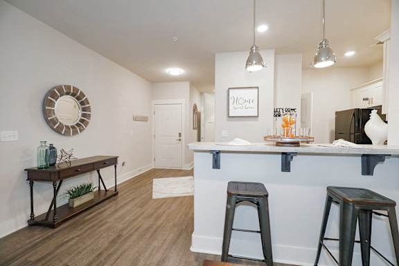 A bar area with two stools and a mirror on the wall at McHenry Square Apartments, Augusta, GA