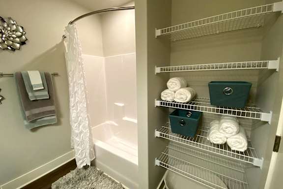 A bathroom with a white shower curtain and a white bathtub at McHenry Square Apartments, Augusta