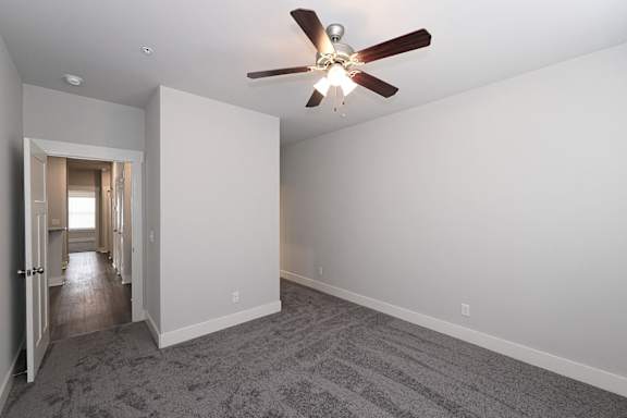 A room with a ceiling fan and carpeted floor at McHenry Square Apartments, Augusta