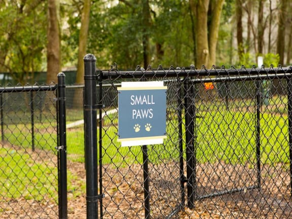 Small paws dog park sign on chain link fence at The Arbor Walk Apartments, Tampa, FL