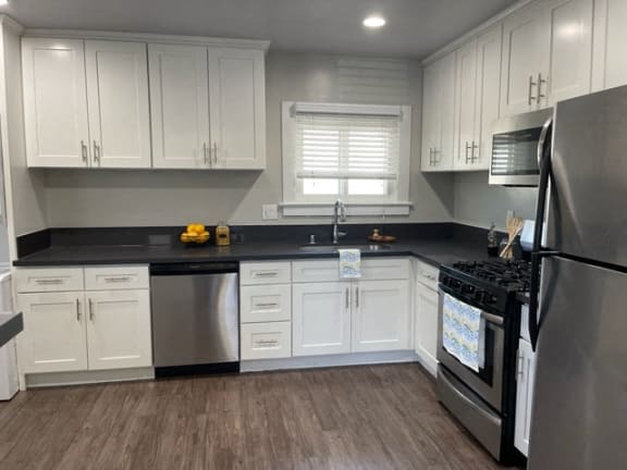 a kitchen with white cabinets and stainless steel appliances