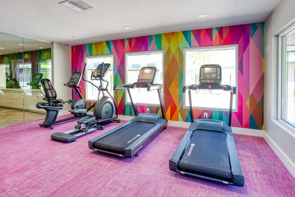 brand new fitness center at Fusion apartments in Las Vegas with treadmills and colorful geometric walls.