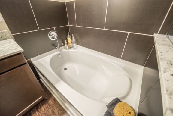 Large Soaking Tub In Master Bathroom With A Tile Surround at Aviator West 7th, Texas, 76107