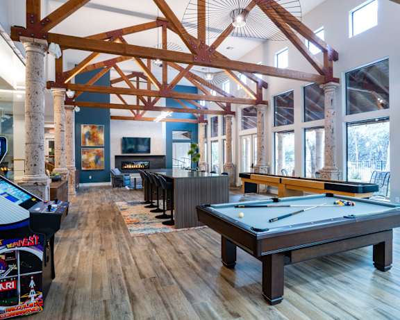 Clubhouse game room with pool table and exposed beams at Nalle Woods of Westlake Apartments, Austin, TX