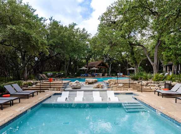 Resort style pool with sun shelf and lounge seating at Nalle Woods of Westlake Apartments, Texas