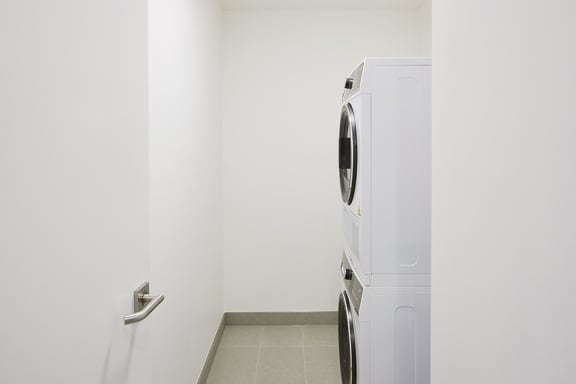 The Briscoe by Kinleaf white washer and dryer in the corner of a room with a door