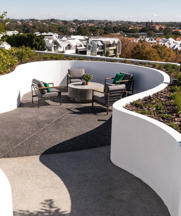 a terrace with chairs and a table on a roof