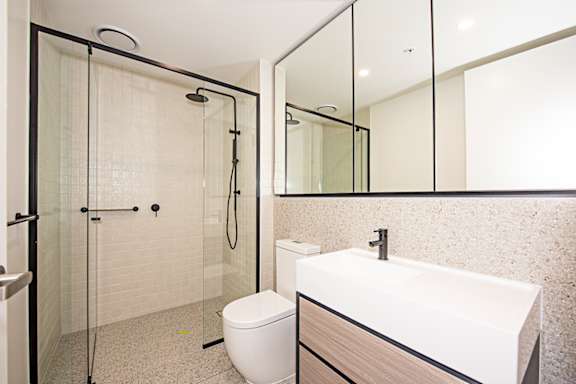A white toilet sits next to a sink in a bathroom.