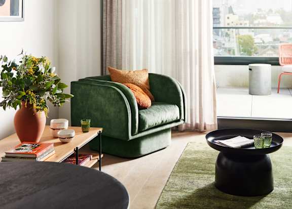 A living room with a green couch and a coffee table.