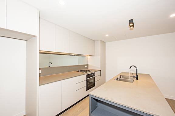 A modern kitchen with a sink and a stove.