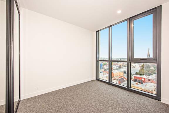 A room with a view of a cityscape through large windows.
