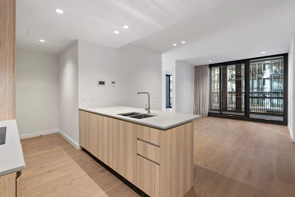 A modern kitchen with wooden cabinets and a white countertop.